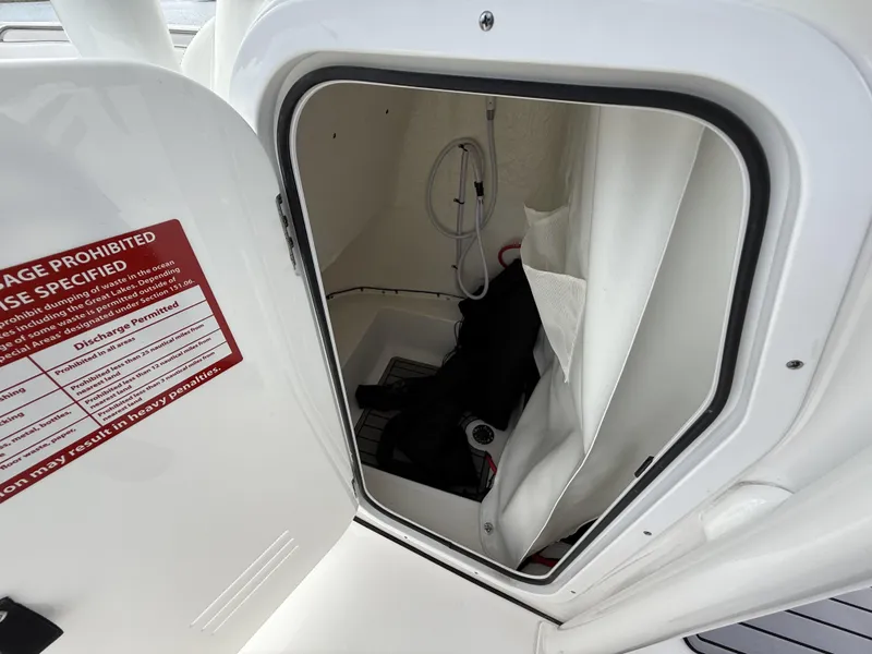 Slide: The Image of 2024 Tidewater 220 CC Adventure boat storage compartment with safety instructions. - 11