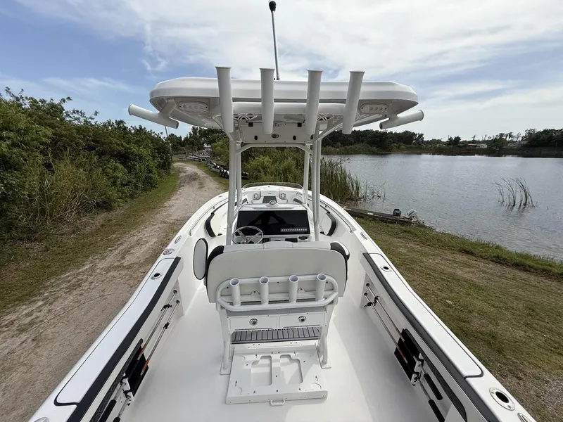 Slide: The Image of 2024 Tidewater 220 CC Adventure boat docked by a serene lake. - 20