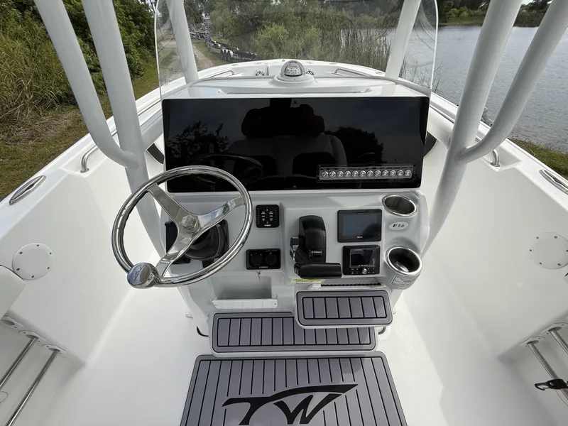 Slide: The Image of 2024 Tidewater 220 CC Adventure boat console with steering wheel and navigation controls. - 22