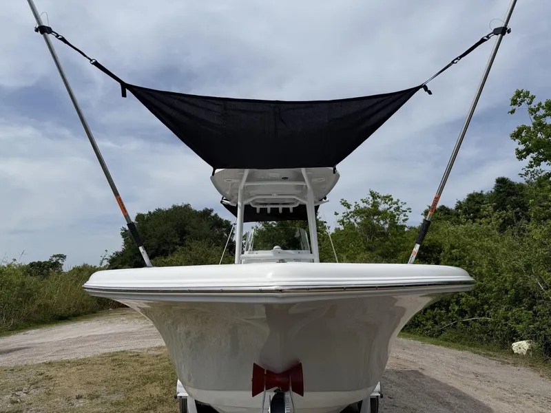 Slide: The Image of 2024 Tidewater 220 CC Adventure boat with canopy, parked on a dirt path. - 38