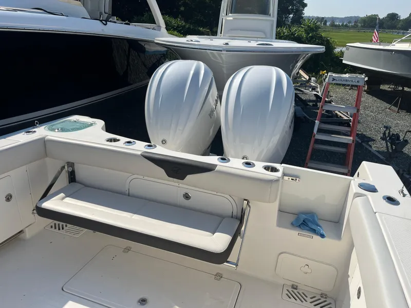 Slide: The Image of 2022 Sailfish 320 CC boat with twin outboard engines and foldable seating. - 10