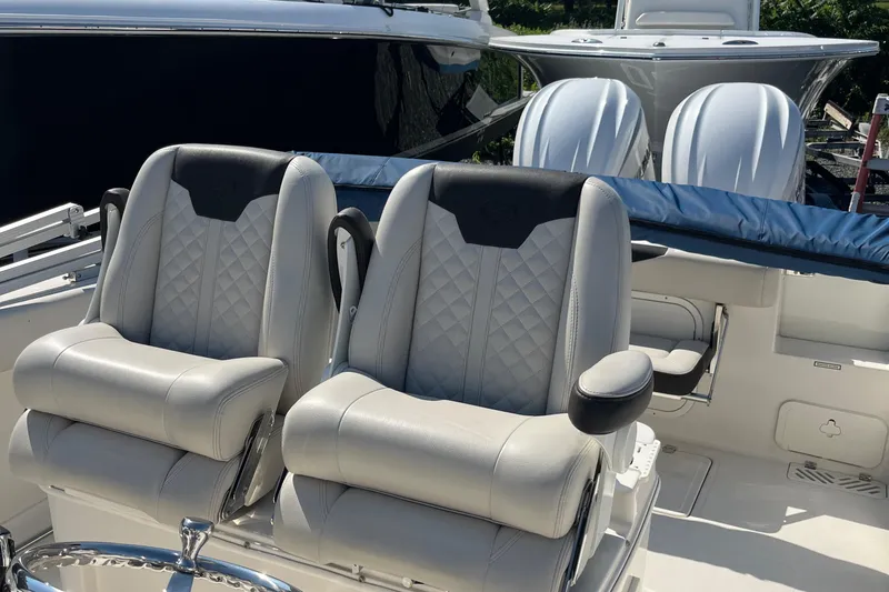 Slide: The Image of 2022 Sailfish 320 CC boat with dual cushioned seats and twin outboard motors. - 19