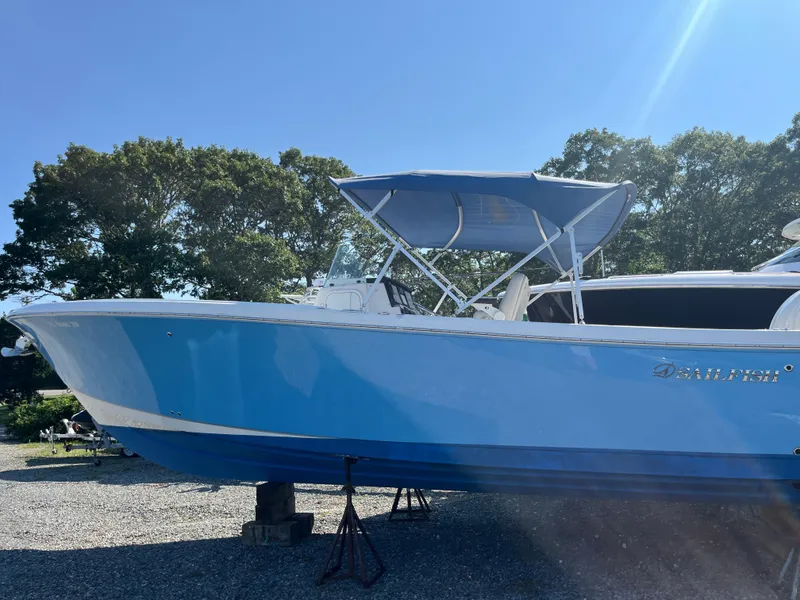 Slide: The Image of 2022 Sailfish 320 CC boat with blue hull on display. - 2