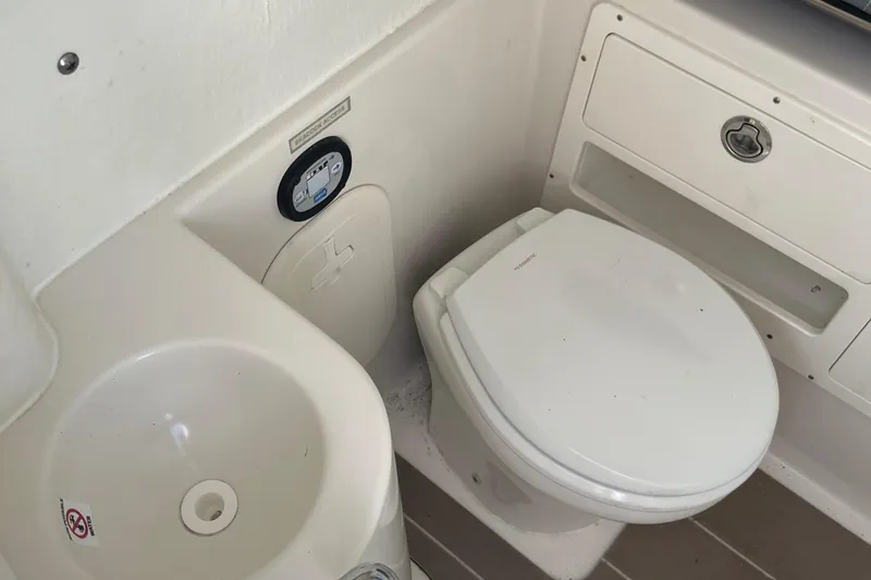 Slide: The Image of 2022 Sailfish 320 CC boat bathroom with toilet and sink. - 20