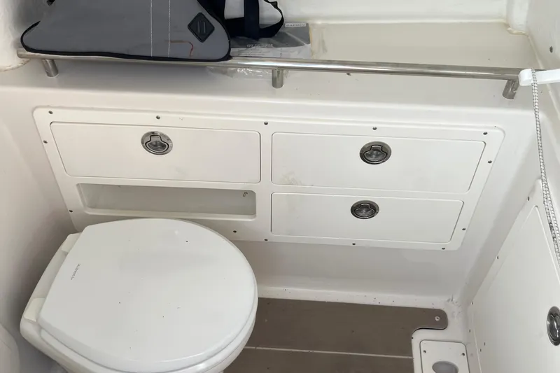 Slide: The Image of 2022 Sailfish 320 CC boat bathroom with toilet and storage cabinets. - 21