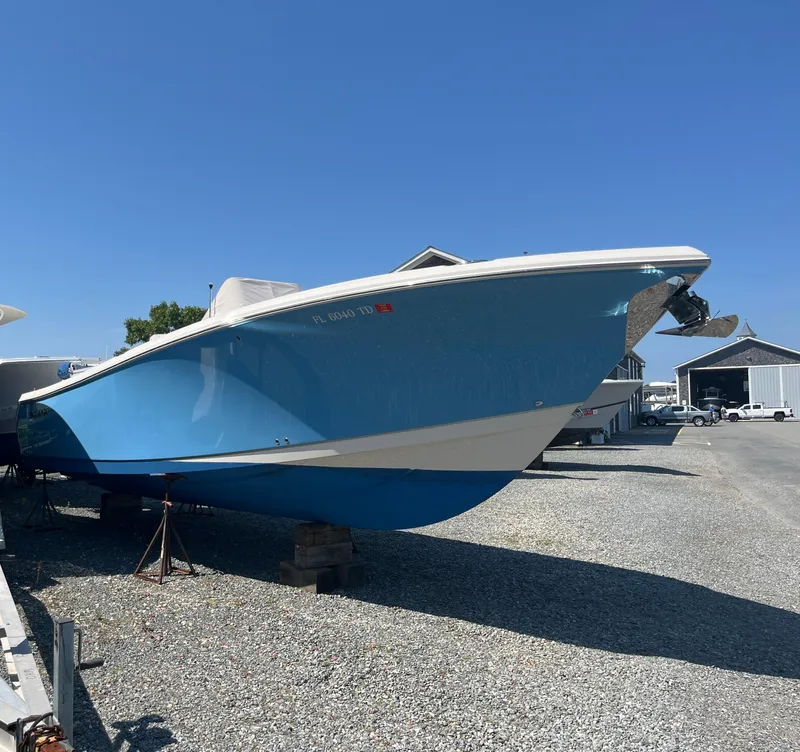 Slide: The Image of 2022 Sailfish 320 CC boat in dry dock, blue hull, sunny day. - 4