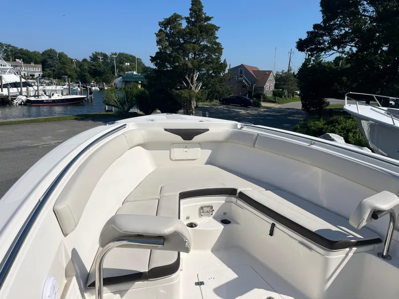 Slide: The Image of 2022 Sailfish 320 CC boat with spacious seating and scenic marina background. - 7