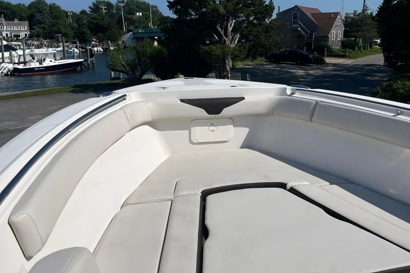 Slide: The Image of 2022 Sailfish 320 CC boat interior with cushioned seating in a marina. - 8