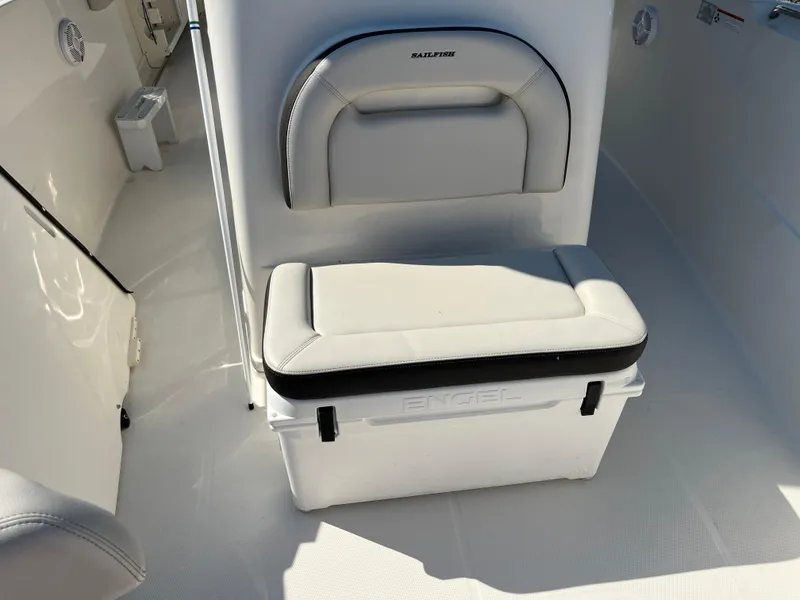 Slide: The Image of 2022 Sailfish 320 CC boat interior with cushioned seating and cooler. - 9