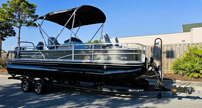 Slide: The Image of 2024 Ranger Reata 220F pontoon boat on trailer, parked outdoors. - 4