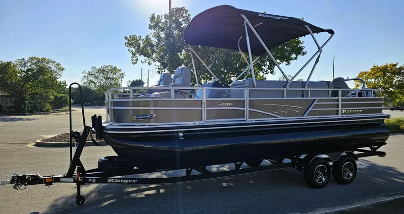 Slide: The Image of 2024 Ranger Reata 220F pontoon boat on trailer, parked outdoors. - 5