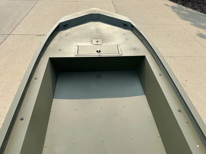 Slide: The Image of 2024 Tracker Grizzly 1754 Jon boat, front view, showing storage compartment and spacious deck. - 3