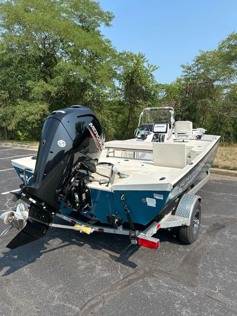 Slide: The Image of 2024 Ranger RB190 boat with outboard motor on a trailer, parked outdoors. - 2