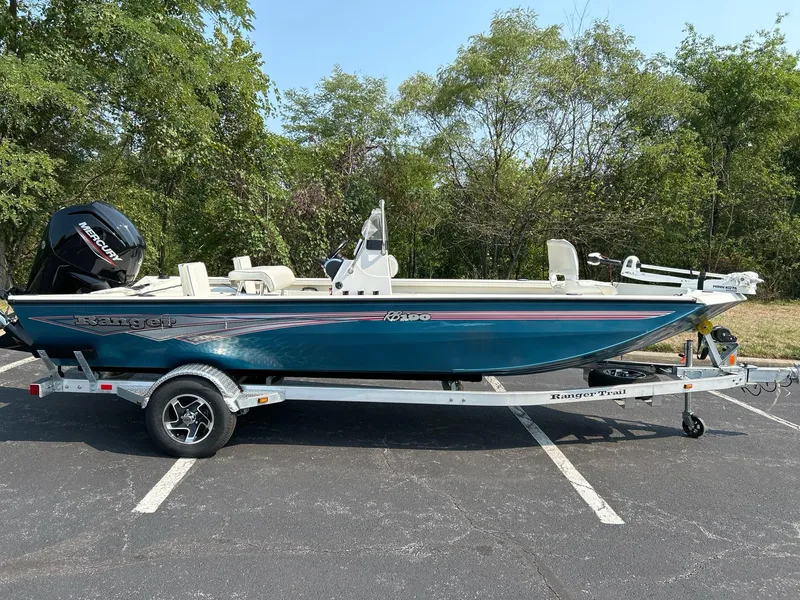 Slide: The Image of 2024 Ranger RB190 boat on trailer, parked outdoors, surrounded by trees. - 3