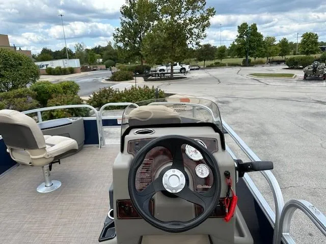 Slide: The Image of 2024 Sun Tracker Bass Buggy 18 DLX pontoon boat interior with steering wheel and seating. - 4