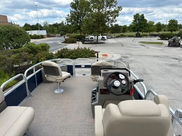 Slide: The Image of 2024 Sun Tracker Bass Buggy 18 DLX pontoon boat with beige seating and steering console. - 6
