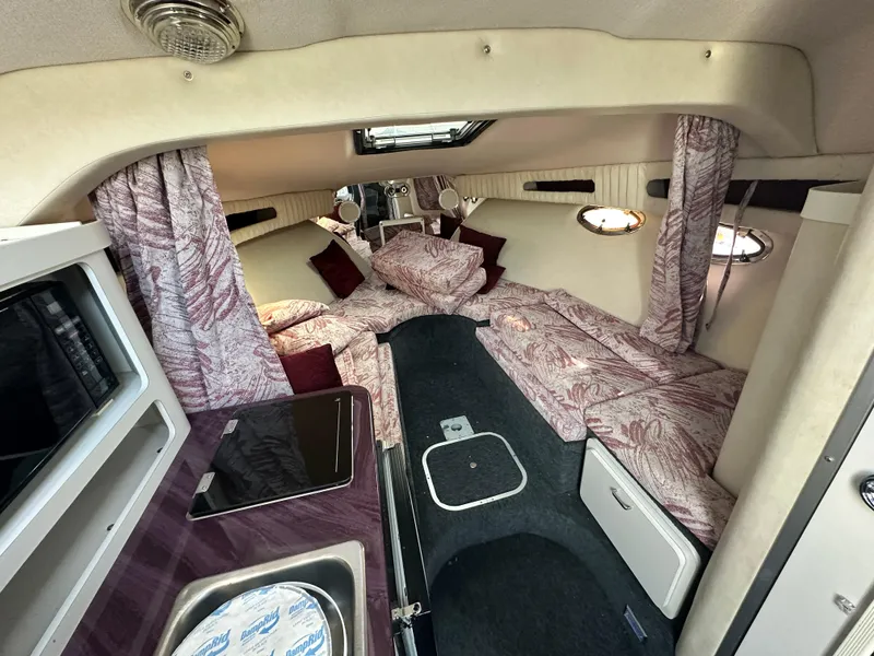 Slide: The Image of Interior of 1994 Crownline 250 CR boat with cozy cabin and patterned bedding. - 14