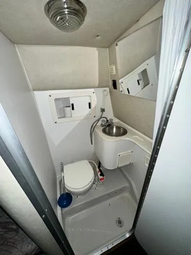 Slide: The Image of 1994 Crownline 250 CR boat bathroom with toilet, sink, and mirror. - 16