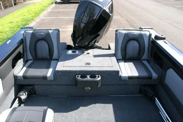 Slide: The Image of 2024 Lund 1975 Tyee Sport boat interior with seating and outboard motor. - 11