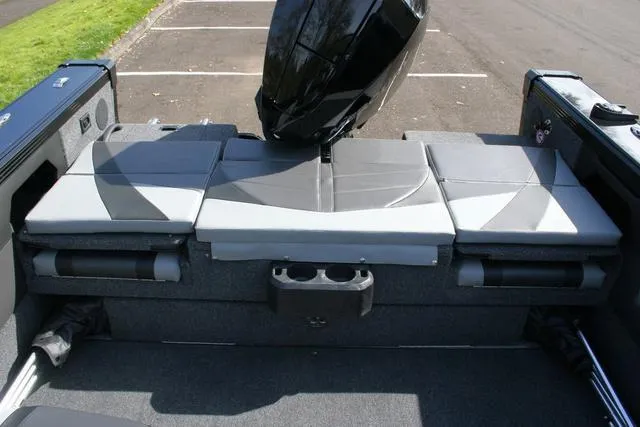 Slide: The Image of 2024 Lund 1975 Tyee Sport boat interior with cushioned seating and motor. - 12