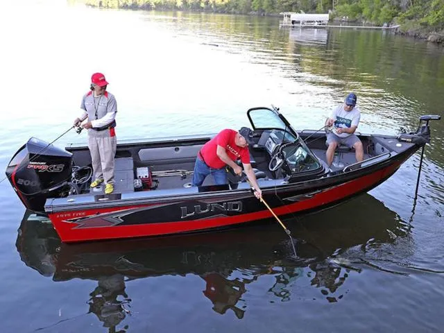 Slide: The Image of Three people fishing on a 2024 Lund 1975 Tyee Sport boat in a lake. - 16