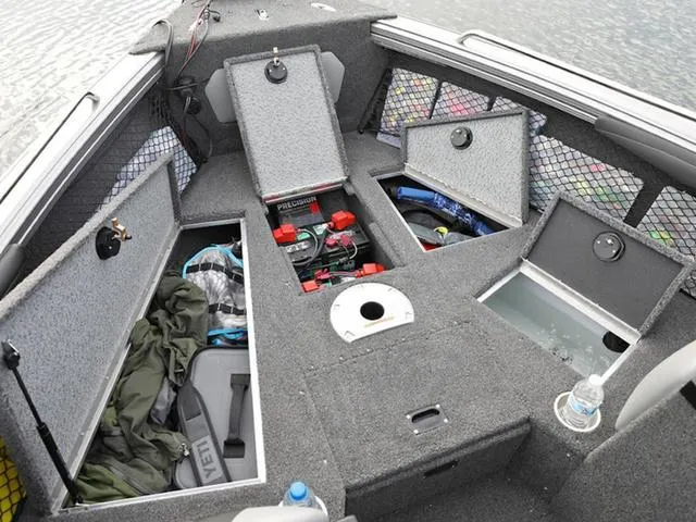 Slide: The Image of 2024 Lund 1975 Tyee Sport boat interior with open storage compartments. - 19