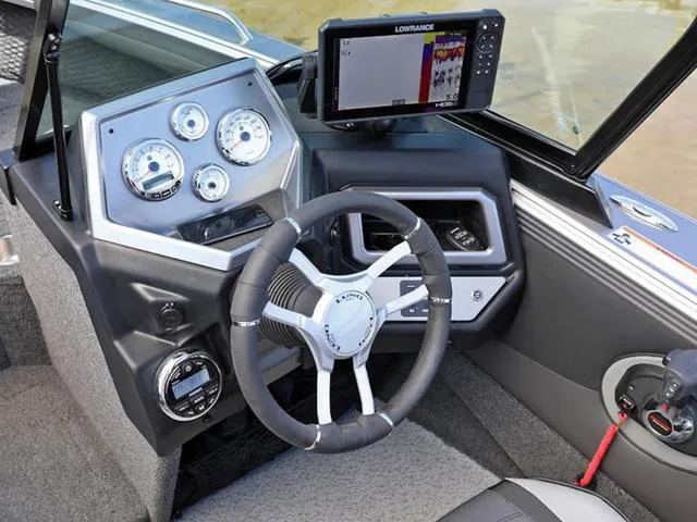 Slide: The Image of 2024 Lund 1975 Tyee Sport boat dashboard with steering wheel and Lowrance fish finder. - 23