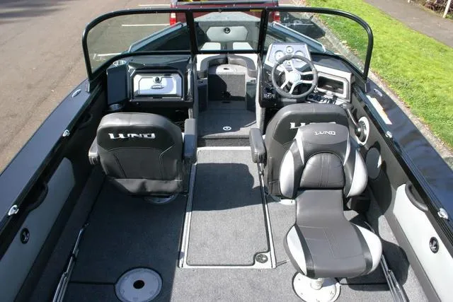 Slide: The Image of 2024 Lund 1975 Tyee Sport boat interior with modern seating and steering console. - 5