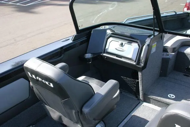 Slide: The Image of 2024 Lund 1975 Tyee Sport boat interior with captain's chair and dashboard. - 7