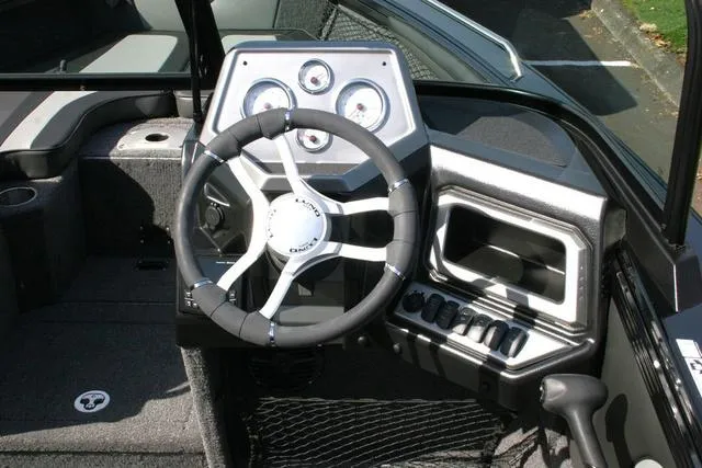 Slide: The Image of 2024 Lund 1975 Tyee Sport boat dashboard with steering wheel and instrument panel. - 8
