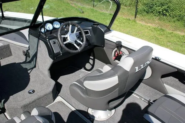 Slide: The Image of 2024 Lund 1875 Crossover XS Sport boat interior with steering wheel and seating. - 6