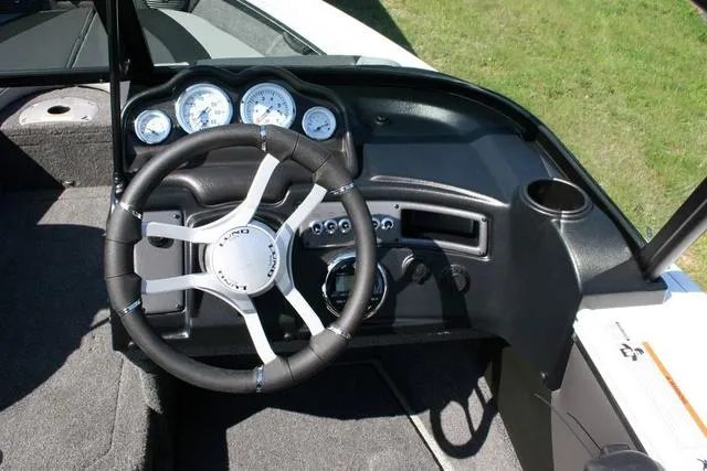 Slide: The Image of 2024 Lund 1875 Crossover XS Sport boat dashboard with steering wheel and gauges. - 8