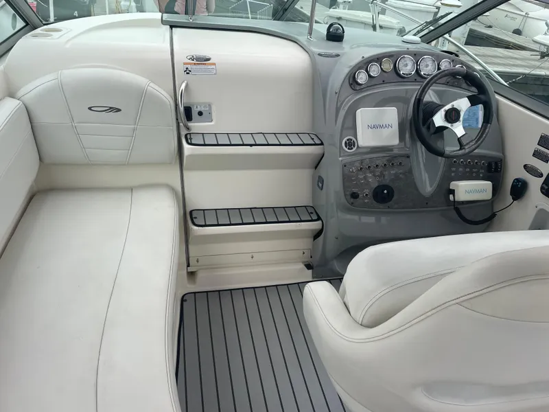 Slide: The Image of 2007 Maxum 2400 SE boat interior with white seating and modern dashboard controls. - 11