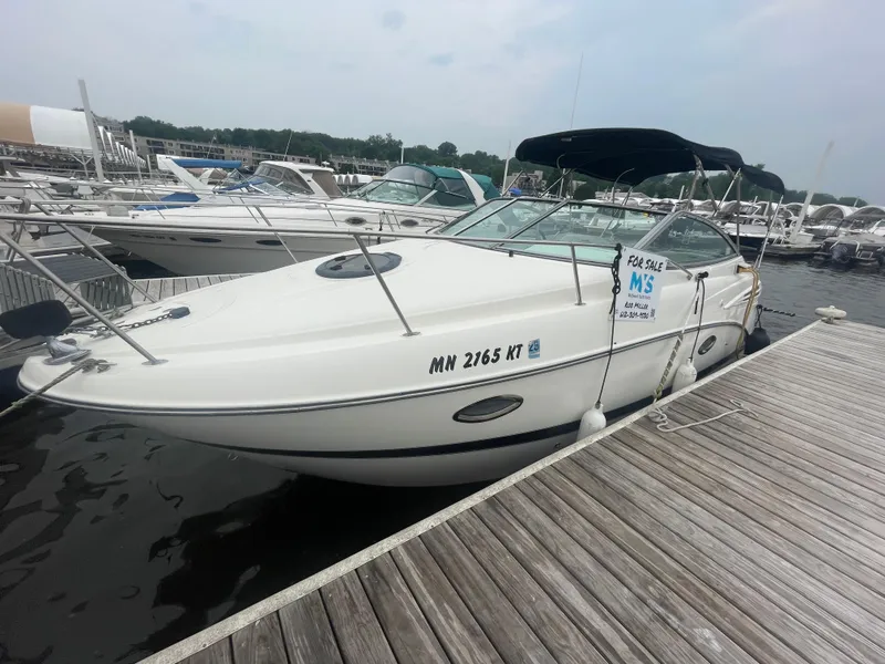 Slide: The Image of 2007 Maxum 2400 SE boat docked, for sale, with a black canopy and white hull. - 15