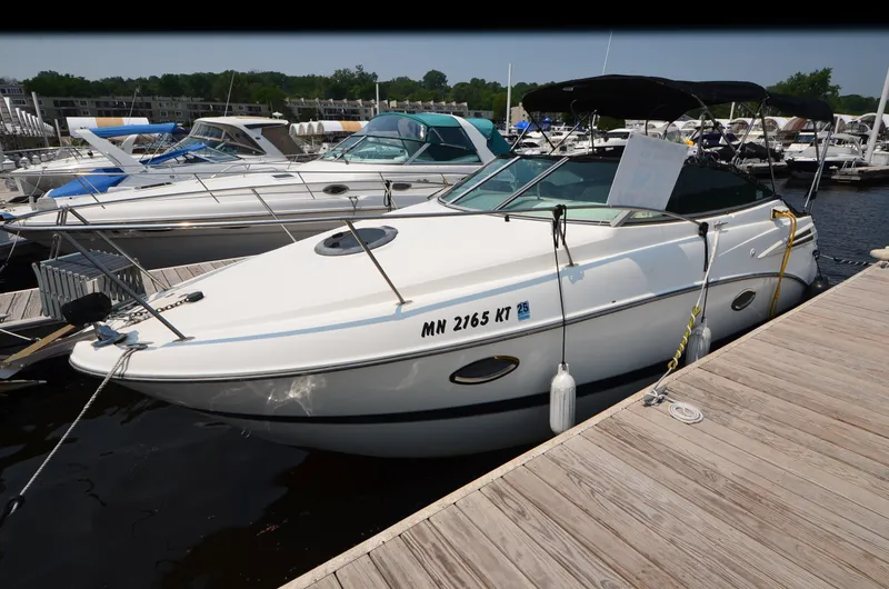 Slide: The Image of 2007 Maxum 2400 SE boat docked at a marina with other vessels. - 16
