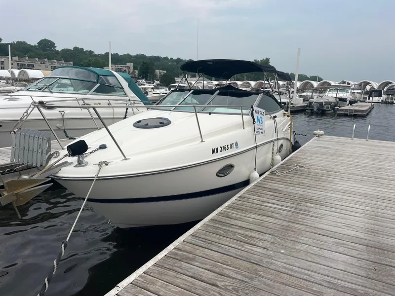 Slide: The Image of 2007 Maxum 2400 SE boat docked at a marina, surrounded by other vessels. - 18