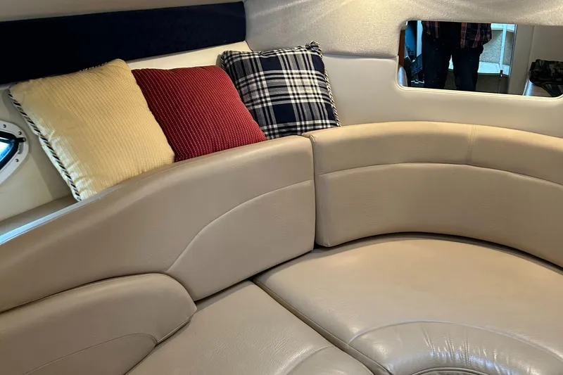 Slide: The Image of 2007 Maxum 2400 SE cabin interior with beige seating and colorful cushions. - 20