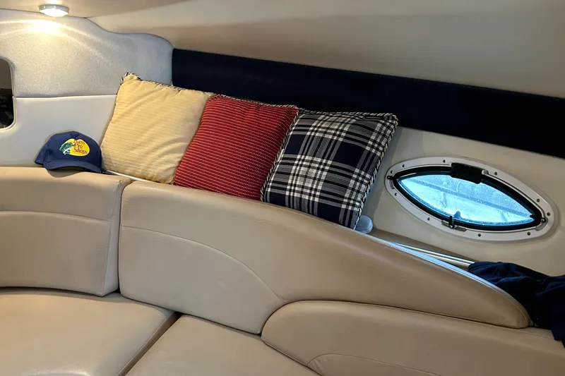 Slide: The Image of Cozy interior of 2007 Maxum 2400 SE boat with cushions and a small window. - 22