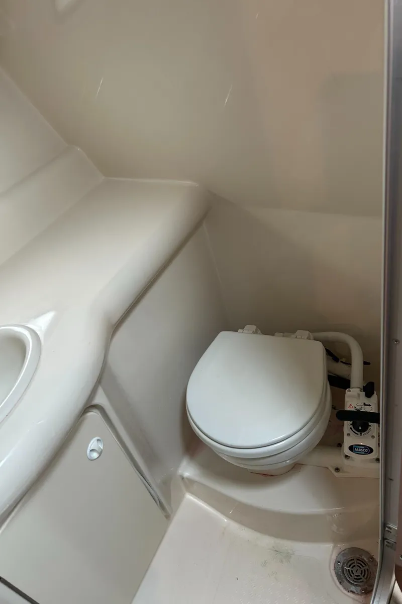 Slide: The Image of 2007 Maxum 2400 SE boat bathroom with compact toilet and sink. - 24