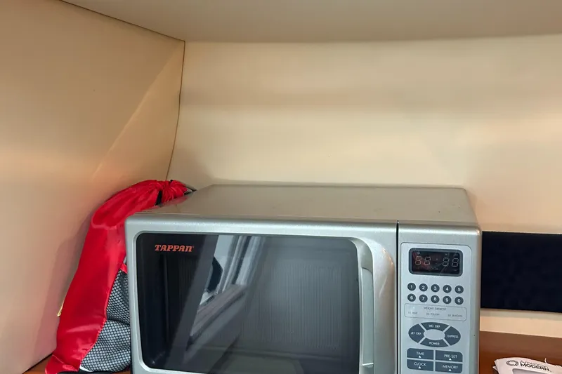 Slide: The Image of Microwave inside 2007 Maxum 2400 SE boat cabin with red bag nearby. - 25