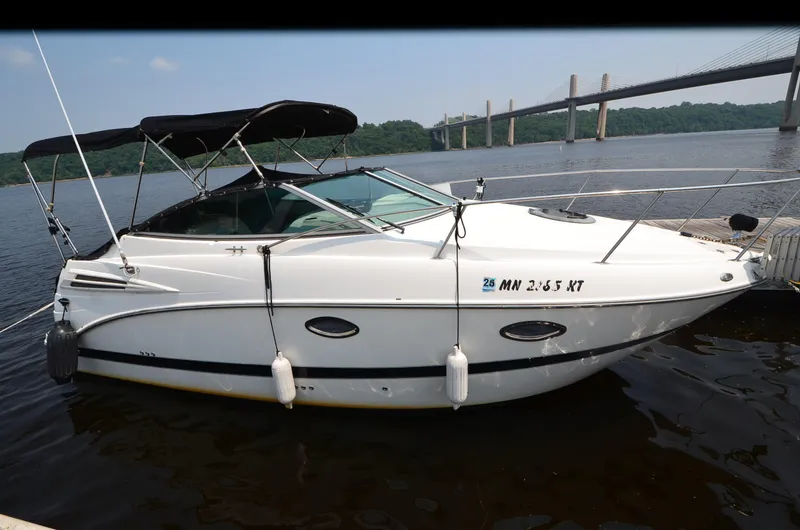 Slide: The Image of 2007 Maxum 2400 SE boat docked by a river with a bridge in the background. - 4