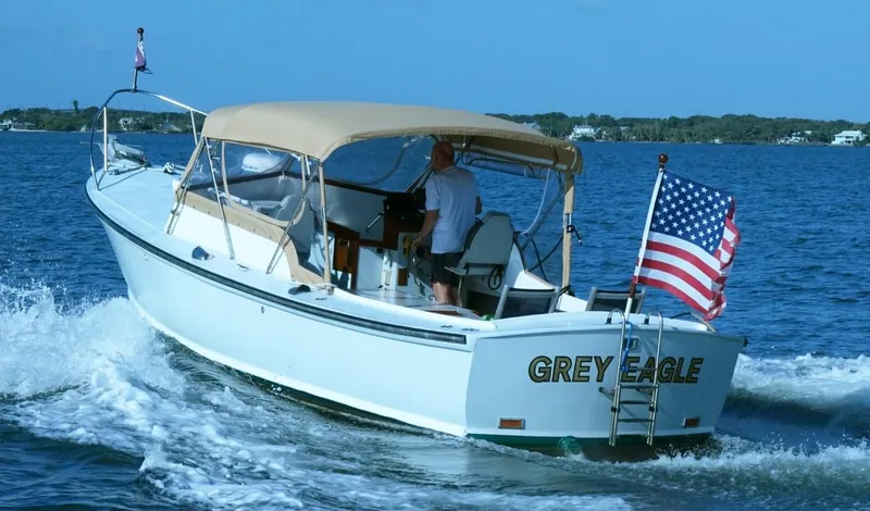 Slide: The Image of 1968 Dyer 29 Bass Boat on water with US flag. - 1