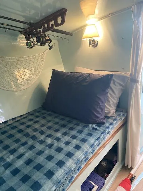 Slide: The Image of Interior of a 1968 Dyer 29 Bass Boat with bed and fishing rods. - 10