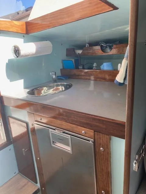 Slide: The Image of Interior of a 1968 Dyer 29 Bass Boat kitchen with sink and storage. - 6