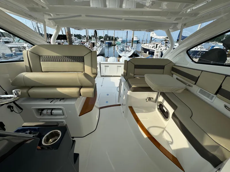 Slide: The Image of Interior of a 2021 Pursuit DC 365 boat with luxurious seating and marina view. - 14