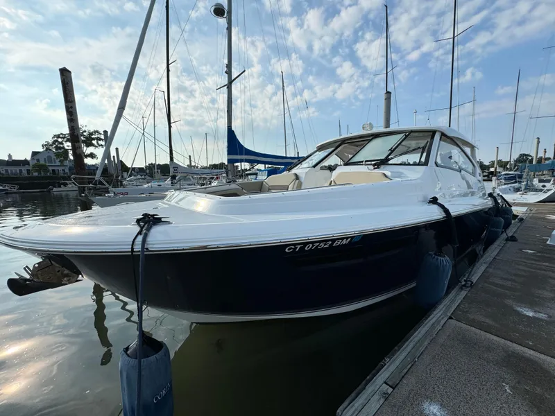 Slide: The Image of 2021 Pursuit DC 365 boat docked at a marina with sailboats in the background. - 4
