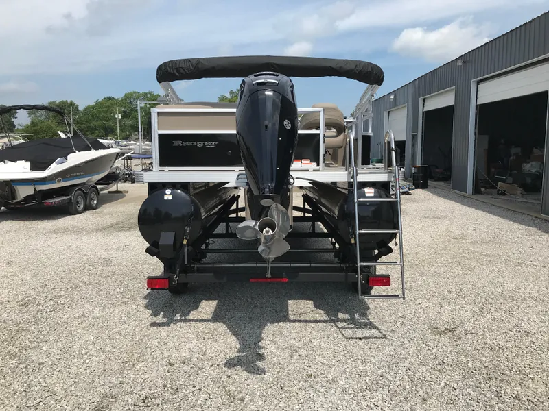 Slide: The Image of 2024 Ranger Reata 200C pontoon boat with outboard motor, parked on gravel lot. - 7