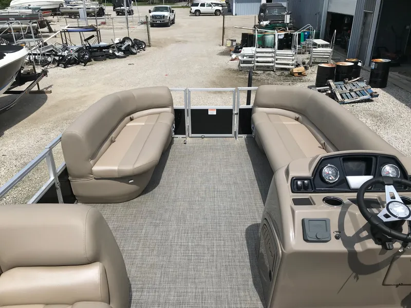 Slide: The Image of 2024 Ranger Reata 200C pontoon boat with beige seating and steering console. - 9
