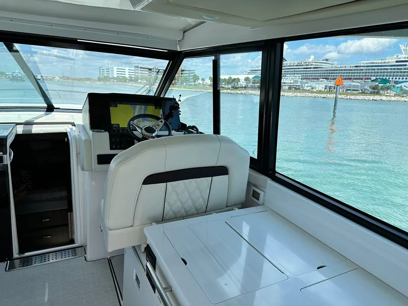 Slide: The Image of Interior of 2023 Regal Grande Coupe yacht with modern helm and waterfront view. - 6