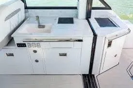 Slide: The Image of 2023 Regal Grande Coupe yacht kitchenette with sink and storage. - 11
